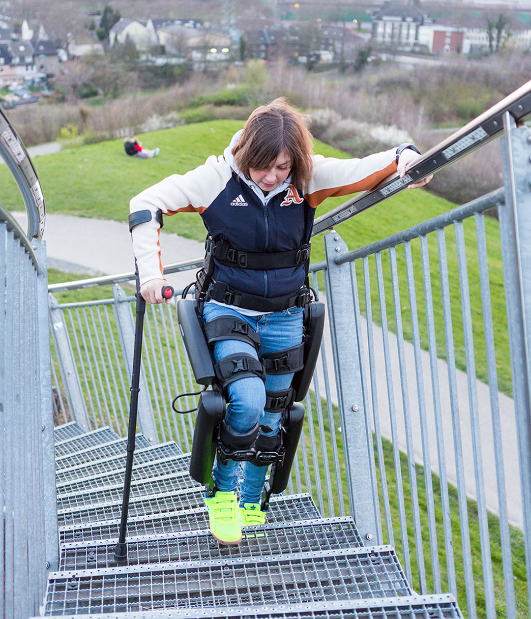 Frau-in-Exoskelett-steigt-selbststaendig-Treppen-hinauf